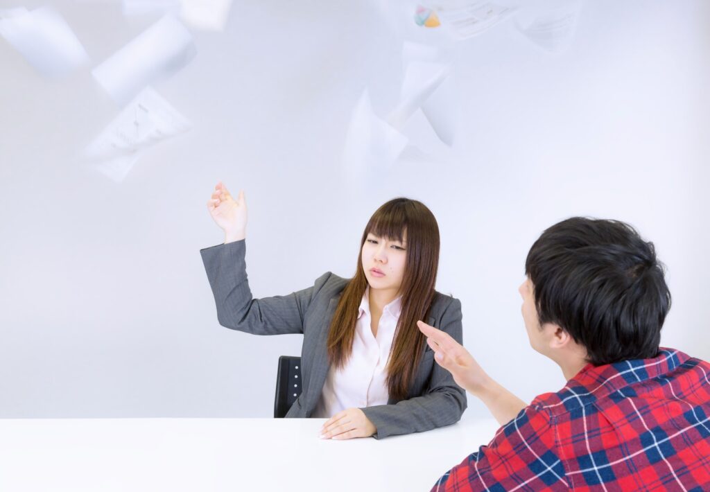 不機嫌な女性。資料を投げ捨てている