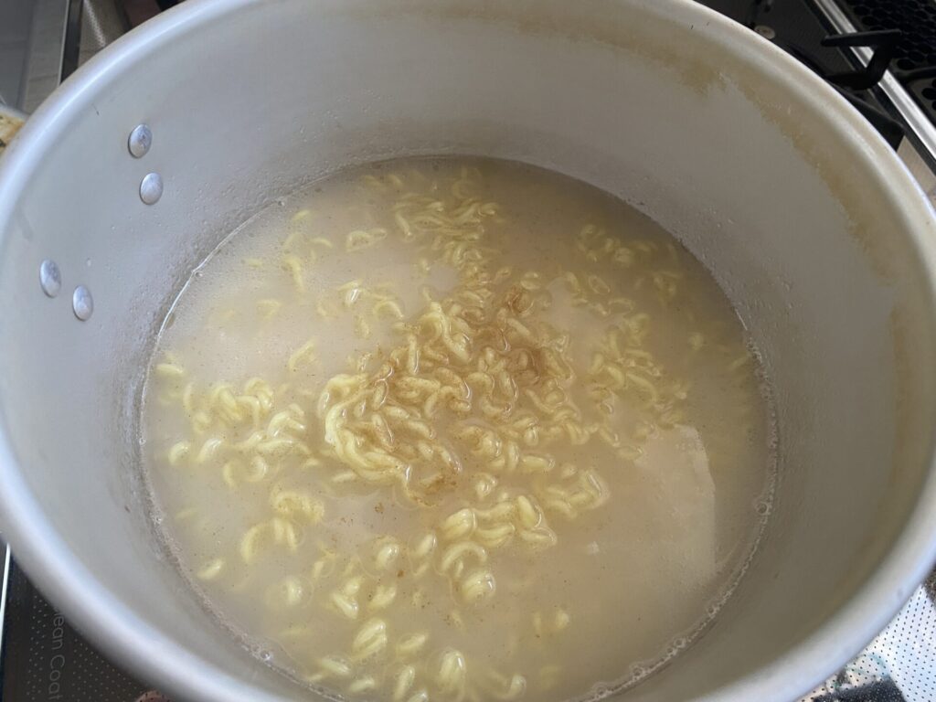 麺が茹で上がったら液体スープと隠し味を入れます。