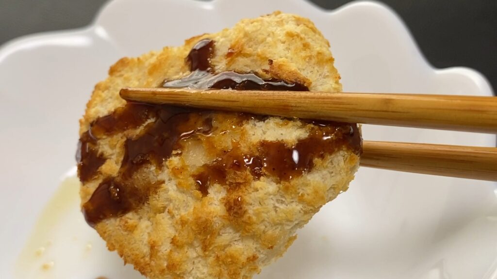 ノンフライヤーで焼かれたチキンカツにソースがかかっている。