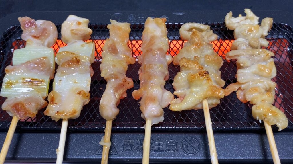 焼き鳥が山善の電気七輪で焼かれ、余分な脂が落ちて肉がカリッと美味しそうに焼き上がっている様子。