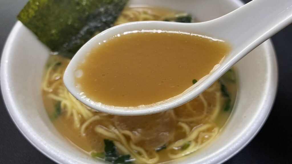 山岡家カップ麺の醤油ラーメンのスープ。店舗のスープに比べ、油が控えめだが色が濃い。