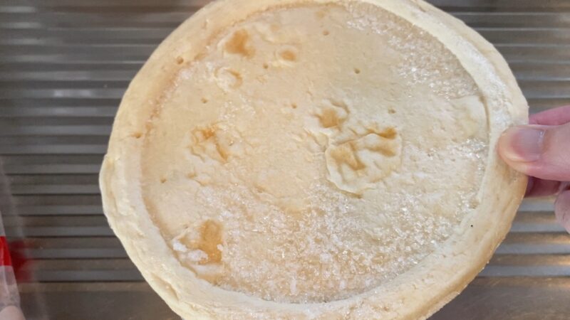 袋から取り出した冷凍状態のピザクラスト。生地の厚みや質感がわかる。