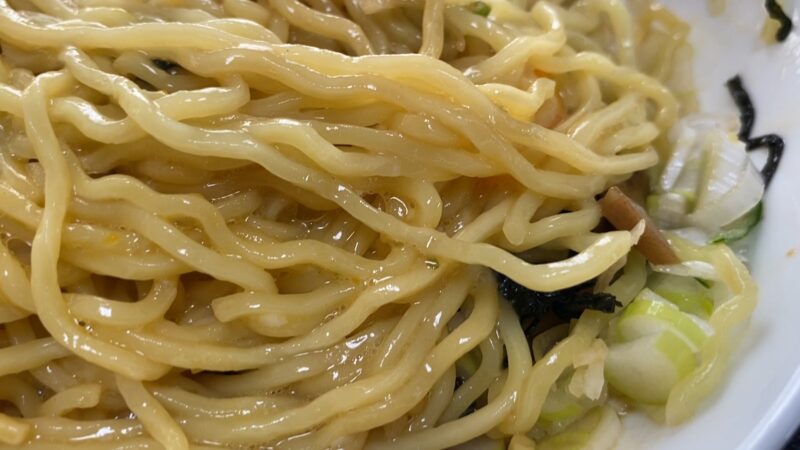 麺のアップ。油の艶があり、刻みネギや海苔が見える