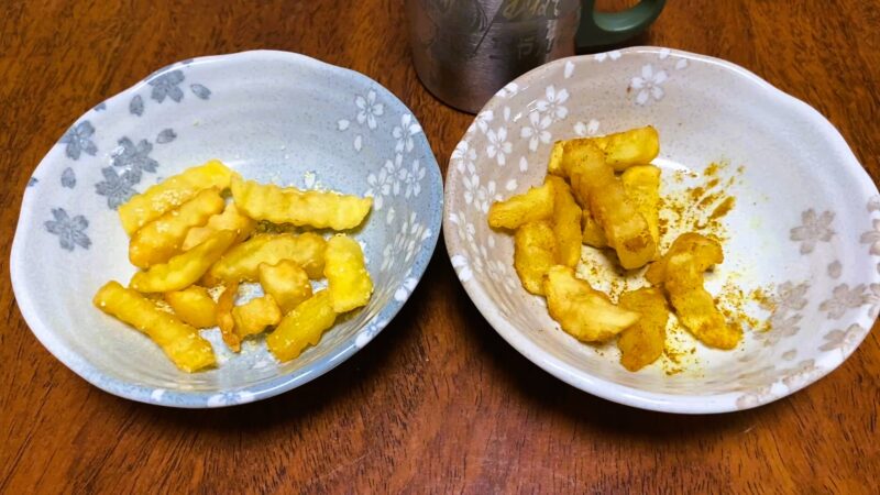 カレー粉とガーリックパウダーをかけたフライドポテトがそれぞれ盛られた2皿。左はガーリックパウダー、右はカレー粉をふりかけた味変スタイル。