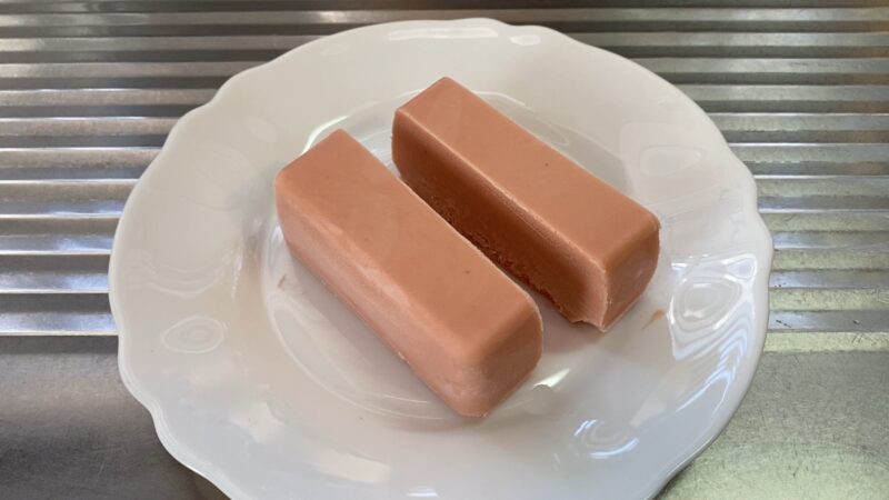 凍ったストロベリーチーズケーキを棒状にカットした2本。皿に盛り付け