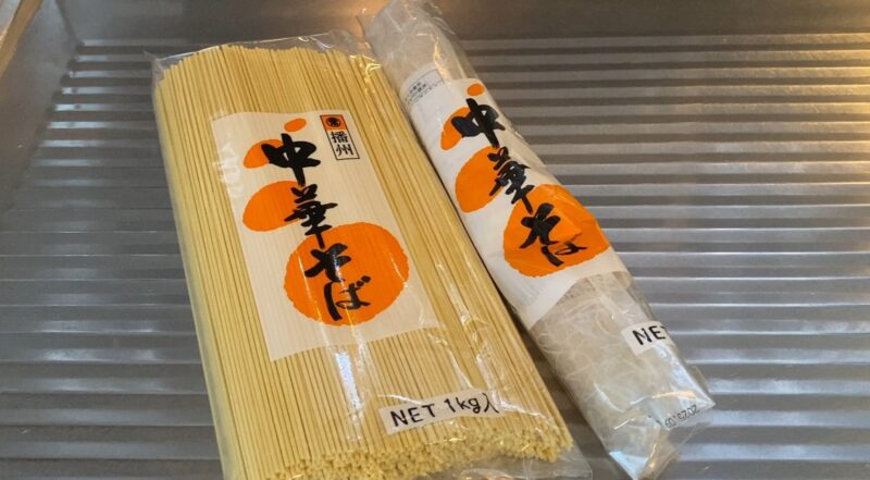 未開封と開封済みの「播州 中華そば(1kg)」が2シンク上に並んでいる。袋越しに中細のストレート麺が見える