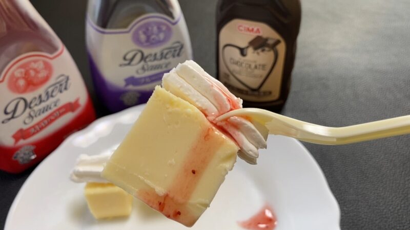 ホイップクリームにいちごソースをかけたチーズケーキ。鮮やかな赤いソースがアクセント。