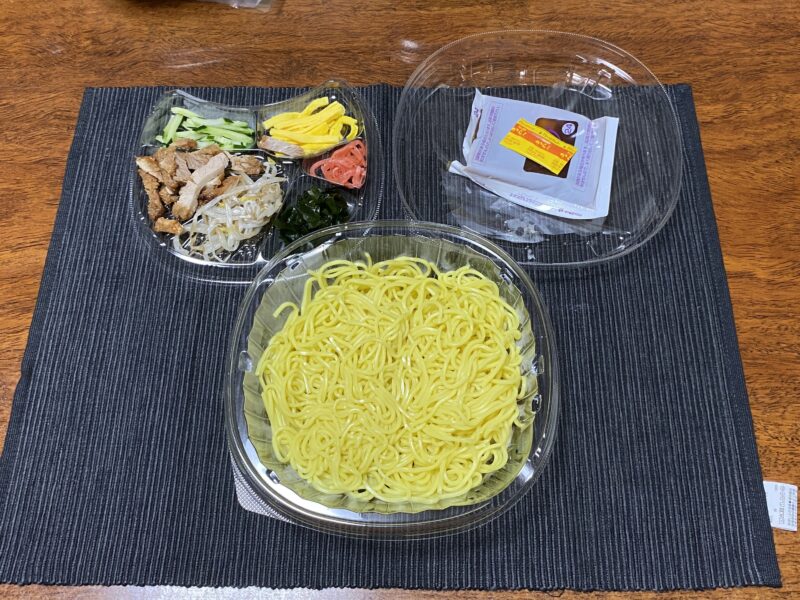 ファミマ冷やし中華のセット内容。麺、6種の具材、醤油だれのスープがパックで分かれて入っている