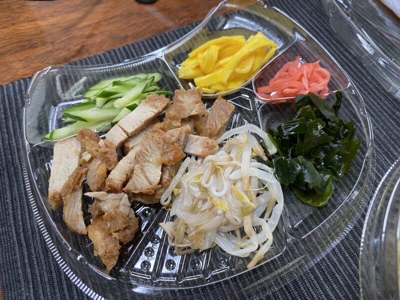ファミマ冷やし中華の具材セット。焼豚、錦糸卵、きゅうり、もやし、わかめ、紅しょうがが彩りよく並ぶ