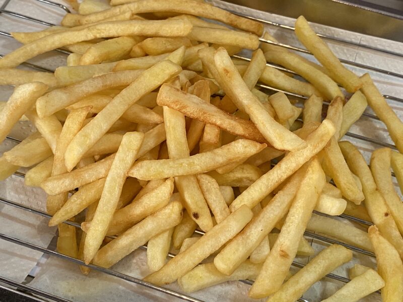 揚げたての業務スーパー冷凍ポテトをバットに広げて冷ましている様子
