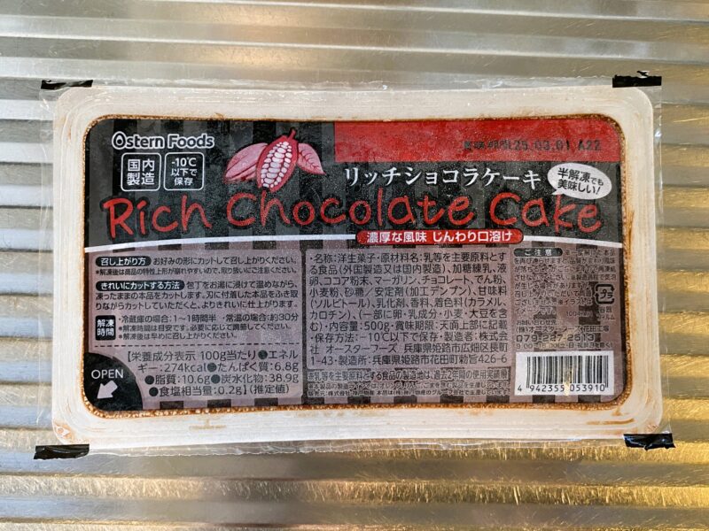 業務スーパーのリッチショコラケーキ。黒と赤のパッケージにカカオのイラスト、原材料や栄養成分表示付き。"
