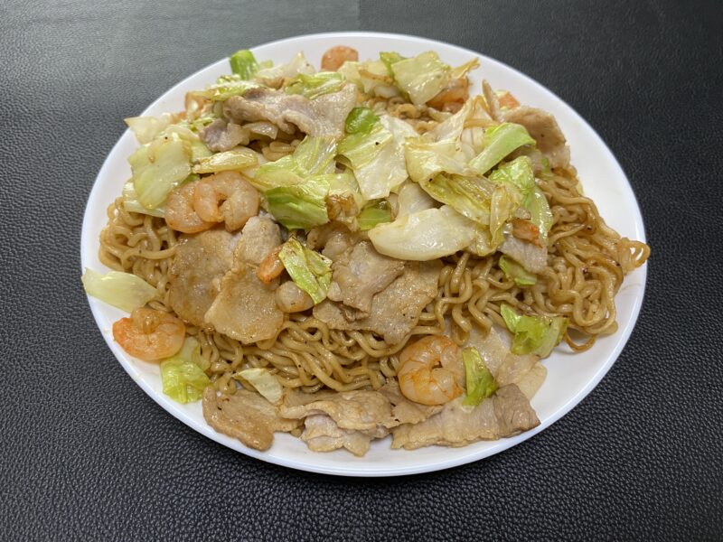 業務スーパーのマレーシア産ノンフライ乾麺を使用したシーフード焼きそば。豚バラ肉、キャベツ、エビが入った彩り豊かな盛り付け。
