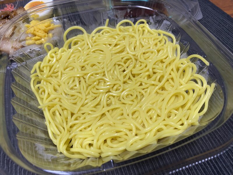 ローソンの冷やし中華用の中華麺。つやのある黄色いストレート麺が盛られている