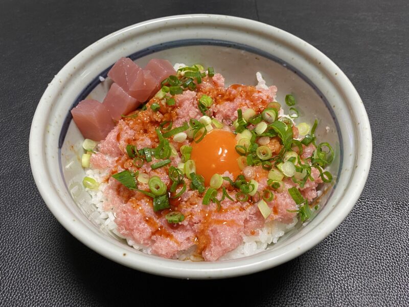 業務スーパーの冷凍マグロたたきを使った丼。卵黄とまぐろ角切りを添えて濃厚な一品に。