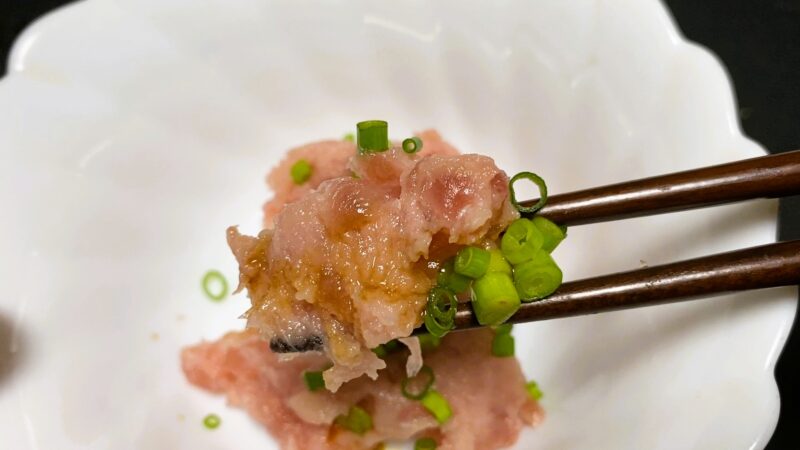 業務スーパーの冷凍マグロたたきを少量取り分け、醤油とネギを添えた食べる直前の状態。少したたき残りが見える
