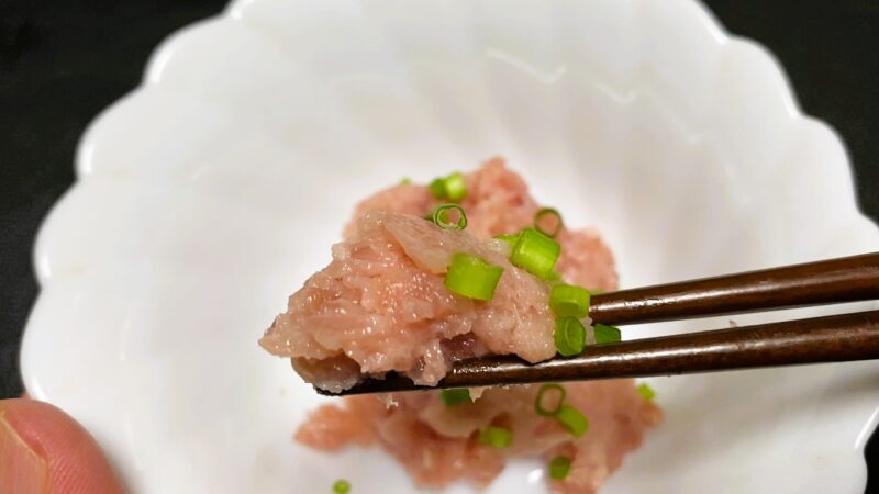 業務スーパーの冷凍マグロたたきで作った軍艦寿司を箸で持ち上げた様子。