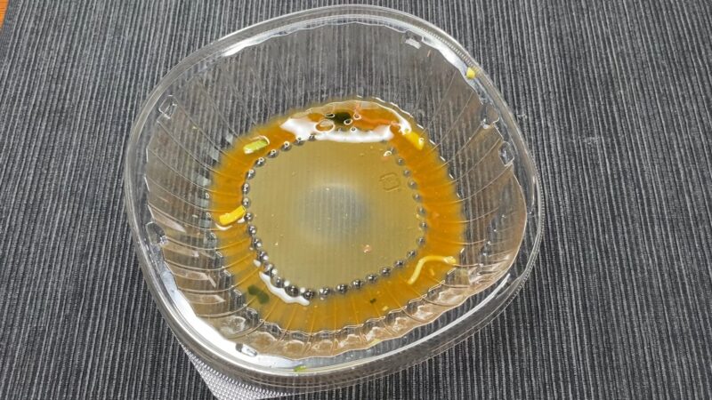 ファミマ冷やし中華を食べ終えた後の容器。底に醤油だれのスープが少し残っている