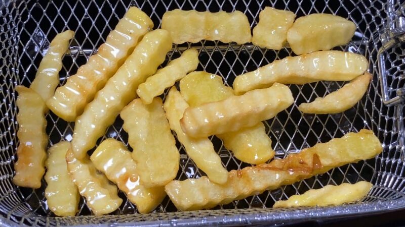 揚げたてのクリンクルカットポテト（油切り中）
