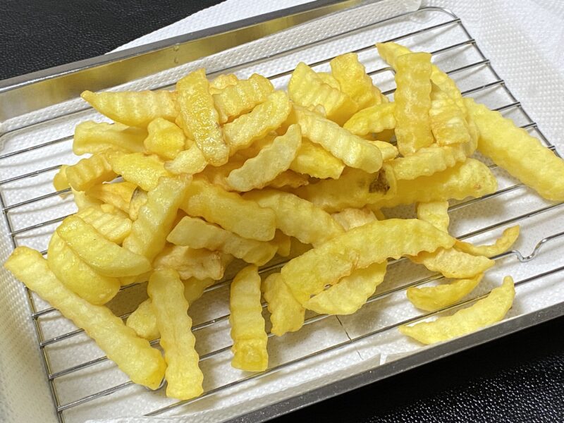 揚げたポテトの油をきっている