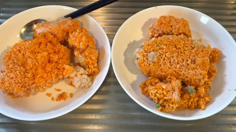 :業務スーパーの冷凍チキンライスを袋から出し、凍ったまま2皿に分けた状態。固まり具合が確認できる。