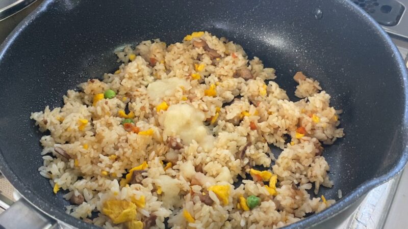 すりおろしにんにくを加えた直後のチャーハン。炒める前で、にんにくが白く目立つ状態。