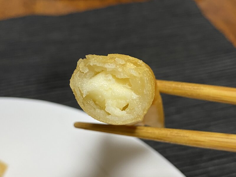 箸で持ち上げたチーズ＆ポテトスティックの断面、中のポテトとチーズが見える