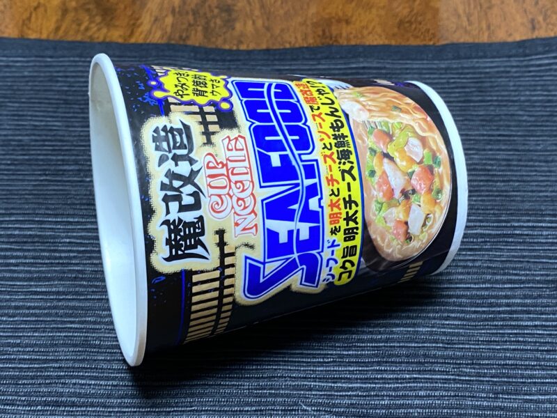 食べ終わった魔改造カップヌードルシーフード味(明太チーズ海鮮もんじゃ)のパッケージが転がっている