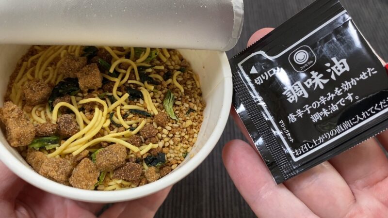 お湯を入れる前のカップ麺と付属の調味油パック