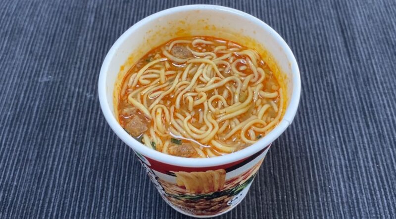完成したファミマ担々麺、赤みのあるスープと麺が見える