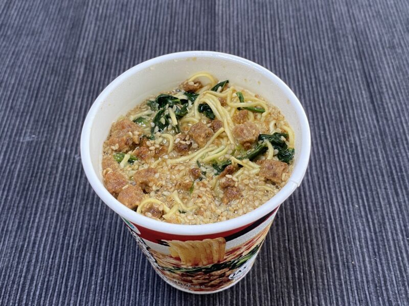 お湯を入れて調理した後の濃厚担々麺、具材が浮かんでいる様子