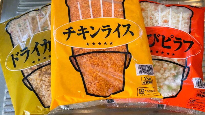 業務スーパーの1kg冷凍ごはんシリーズ「ドライカレー」「チキンライス」「エビピラフ」のパッケージを並べた写真