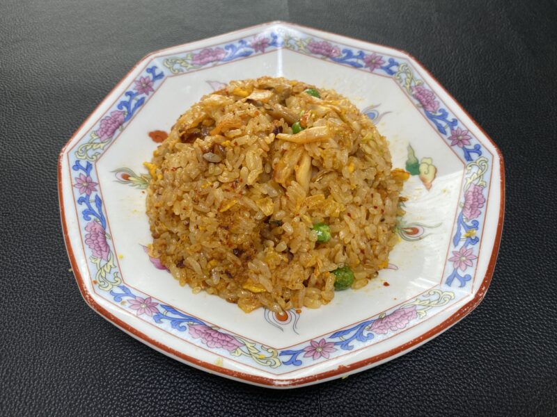 冷凍チャーハンにキムチを加えてアレンジした一皿。ピリッとした辛さと酸味が加わり、赤みがかった見た目が印象的。
