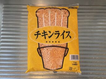 キッチンのシンク上に置かれた、業務スーパーの冷凍チキンライス1kgパッケージ。全体がきれいに写っている。