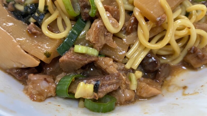 まぜそばの中の煮豚と具材のクローズアップ
