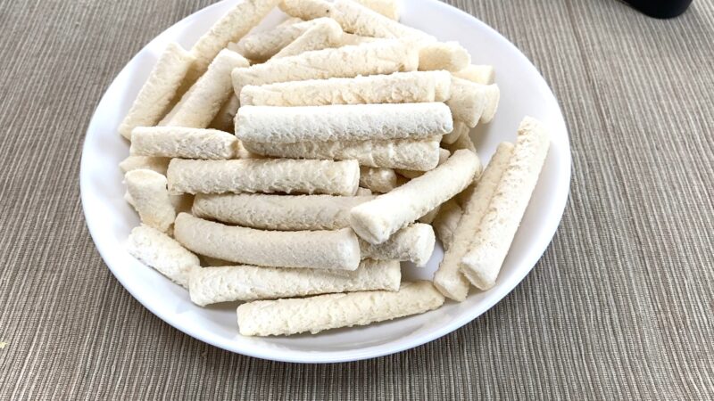揚げてこんがり色づいたもちもちポテトフライを箸で持ち上げた様子