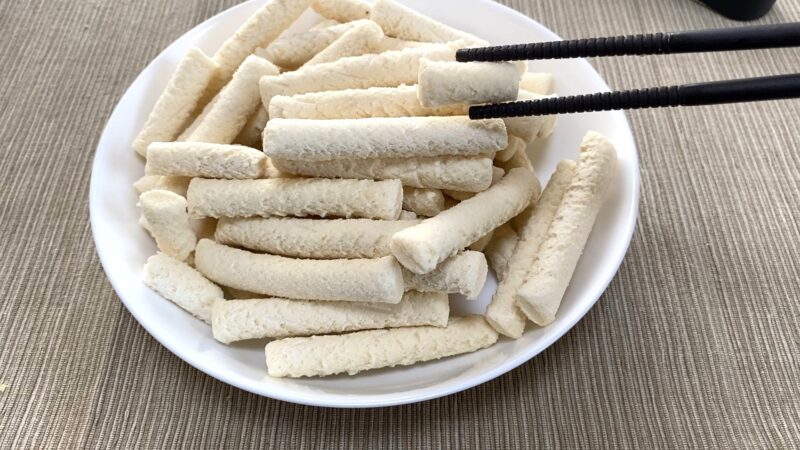 調理前のもちもちポテトフライを短いものだけ箸でつまんでいる様子