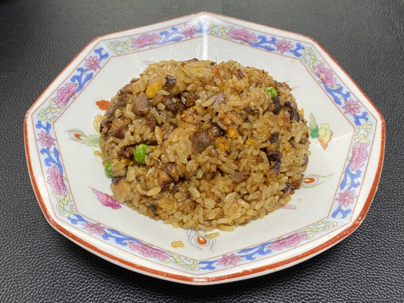 業務スーパーの冷凍チャーハンに煮豚を加えて炒めたアレンジ。肉の旨味がご飯に染み込み、香ばしい焼き目が特徴。