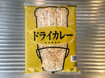 業務スーパーで販売されている「冷凍ドライカレー1kg」のパッケージ。黄色の袋にドライカレーが盛られた皿の写真が印刷されている。