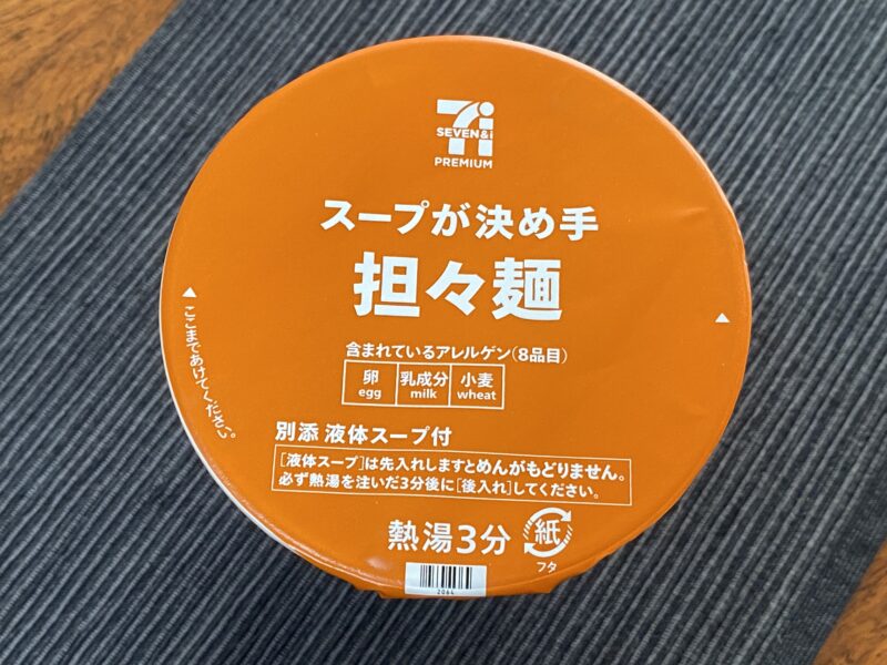 「スープが決め手 担々麺」のフタ部分。オレンジ色のデザインが特徴