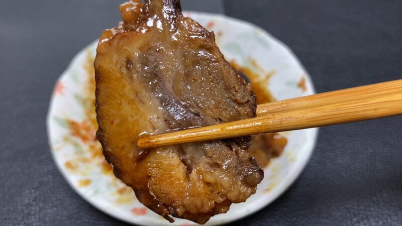 箸で持ち上げた1枚の煮豚