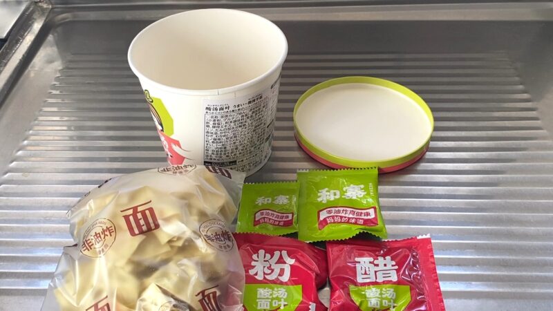 カップの中身を広げた様子。袋入り麺と4種類の小袋が並んでいる
