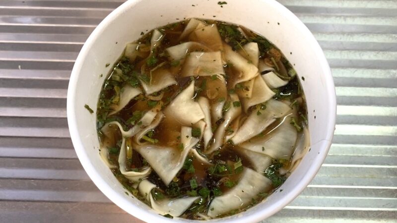 完成した酸湯面叶の様子。幅広の平麺が酸味のあるスープに浮かび、パクチーや香草が散らされている