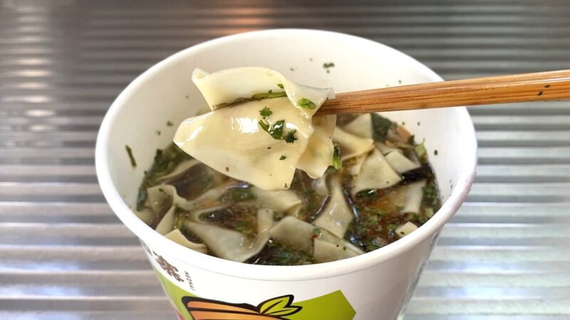 箸で持ち上げた酸湯面叶の幅広麺。スープが絡み、モチモチした食感が伝わる。