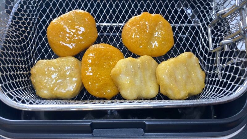 油で揚げたチキンナゲット。衣がカリッときつね色に仕上がり、表面がツヤのある香ばしい見た目。
