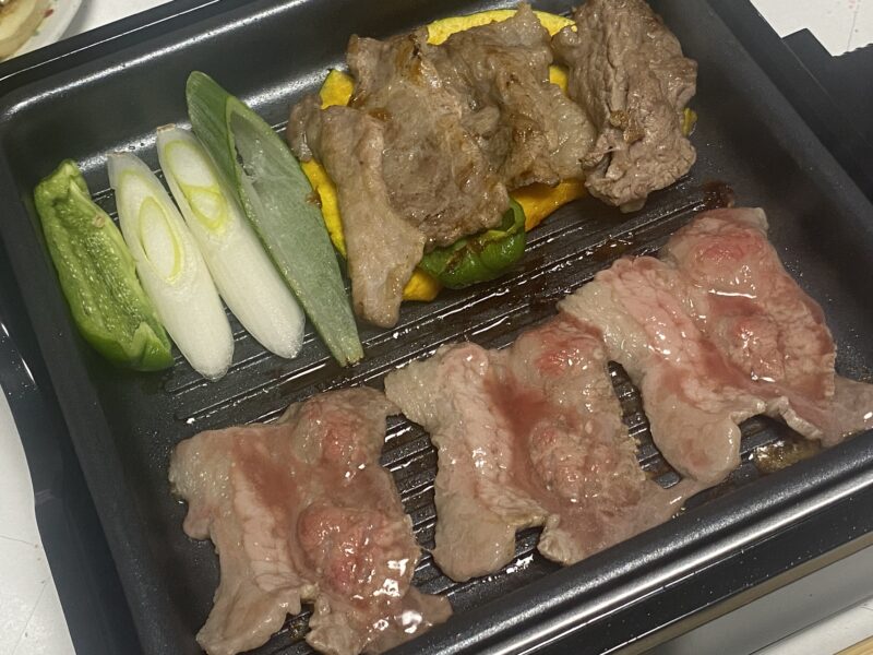 波型プレートで焼かれた牛肉と野菜。ネギやピーマン、かぼちゃが並び、香ばしい焼き目がついた状態。