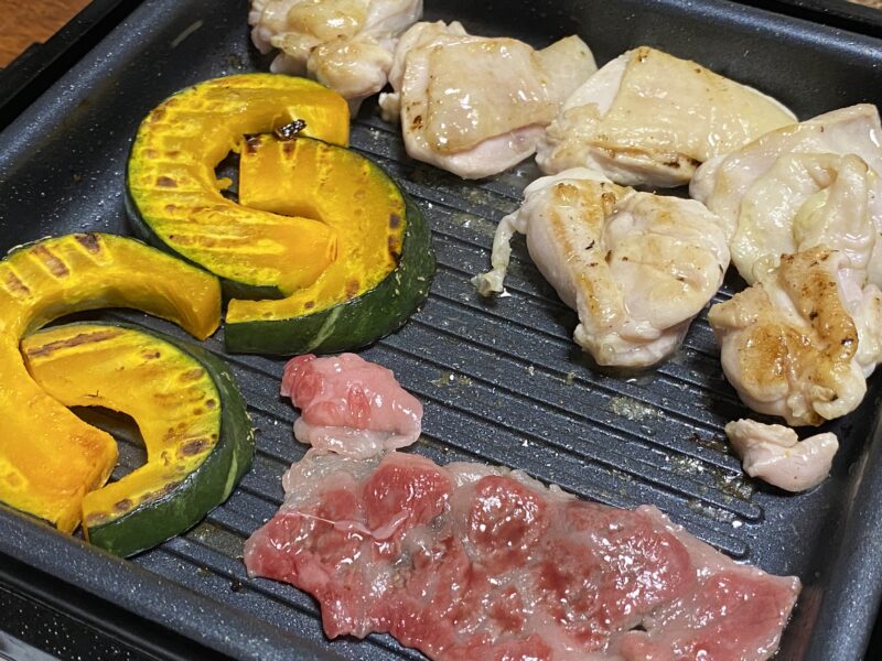波型プレートで鶏肉とかぼちゃを焼いている様子。山善のホットプレート YHC-W601を使った調理例。