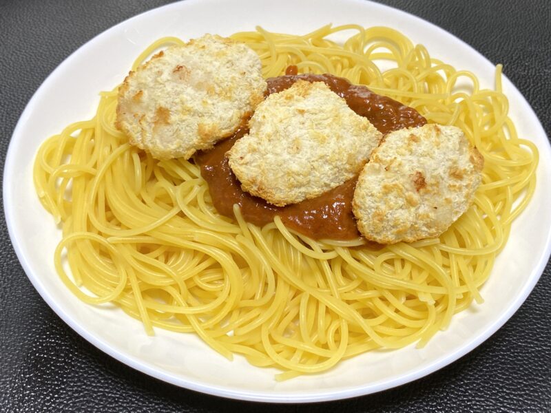 ミートソーススパゲティにチキンカツを3枚トッピング。ソースの上に軽く乗せたシンプルな盛り付け。