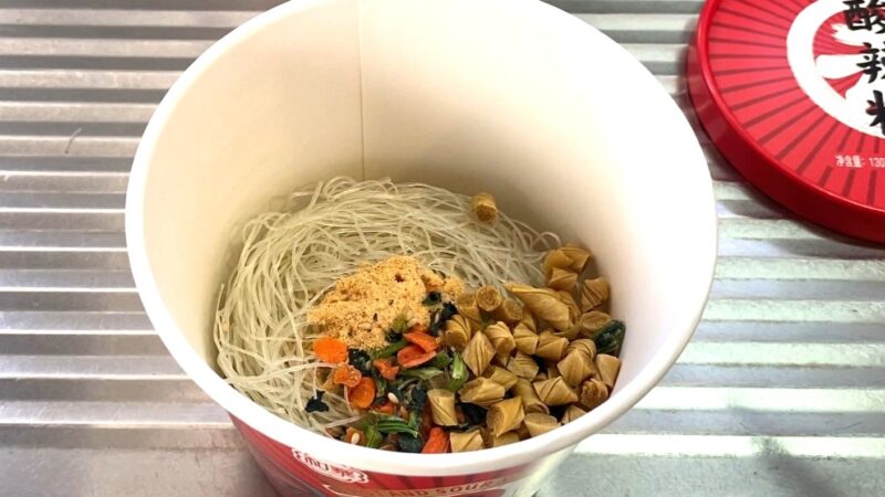 カップに春雨と乾燥具材を入れた状態。色とりどりの野菜や揚げ豆腐が見える。