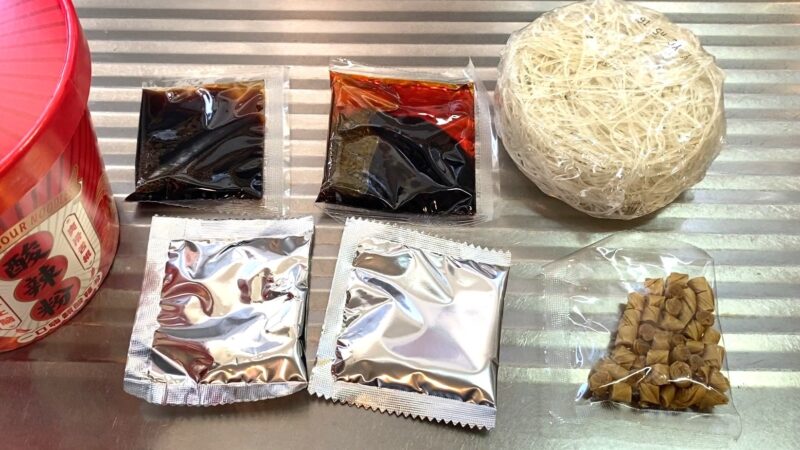 酸辣粉の中身。春雨・液体スープ・粉末調味料・乾燥具材など5種類の袋が並んでいる。