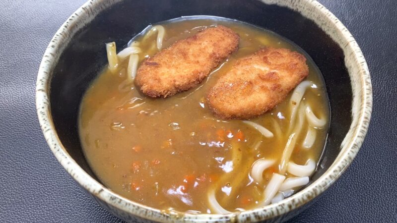 業務スーパー「肉厚 極旨とんかつ」をトッピングしたカレーうどん。サクッと揚がったとんかつがカレーに浸かり、濃厚なルーと太めのうどんがよく絡んでいる。